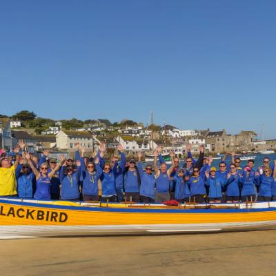 Clevedon Pilot Gig Club stood in front of Blackbird, the gig boat